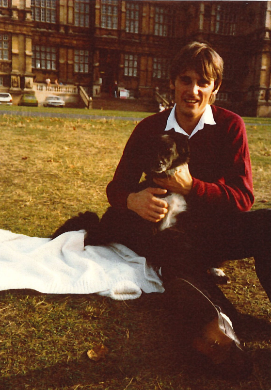 An image of a younger Roy Morris on a field holding a dog